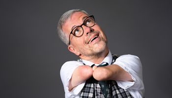 Rainer Schmidt hat seine verkürzten Arme ohne Hände nur mit einem Däumchen zusammengelegt und schaut nach oben