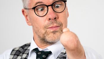 Rainer Schmidt schaut auf seinen verkürzten Unterarm mit einem einzelnen Däumchen