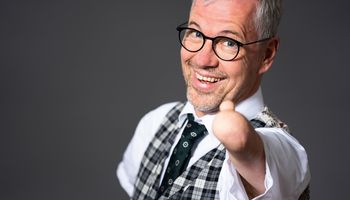 Rainer Schmidt streckt einen verkürzten Unterarm ohne Hand dem Betrachter entgegen und reckt seinen Daumen nach oben. Es ist der einzige Finger am Arm.